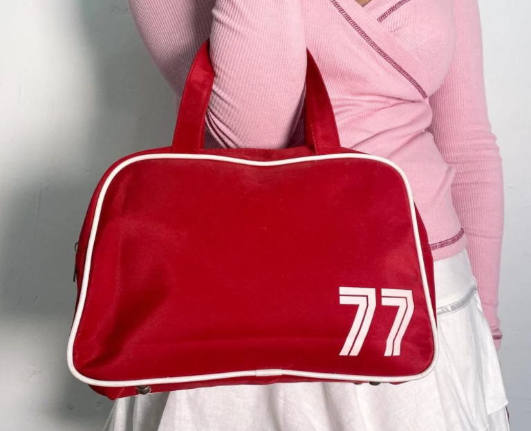 Woman holding a red bag with 77 on it