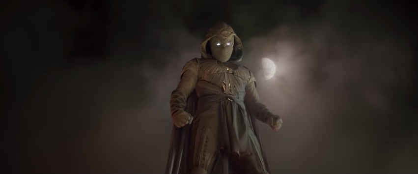 Moon Knight stands before a foggy moon-lit sky in costume