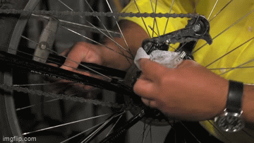 a gif of a person using the wipes to clean a dirty bike chain
