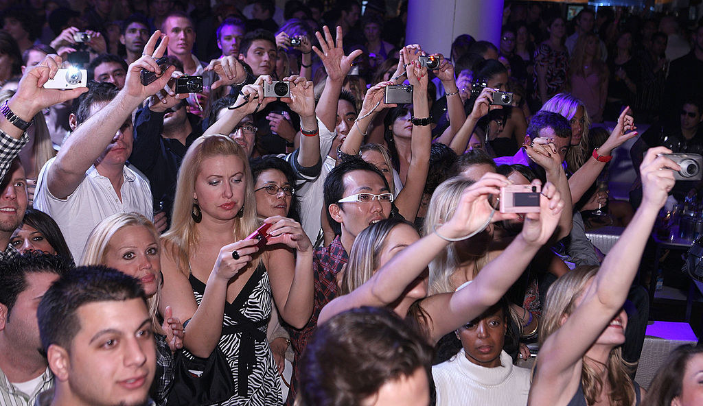 A crowd holding up digital cameras at a concert