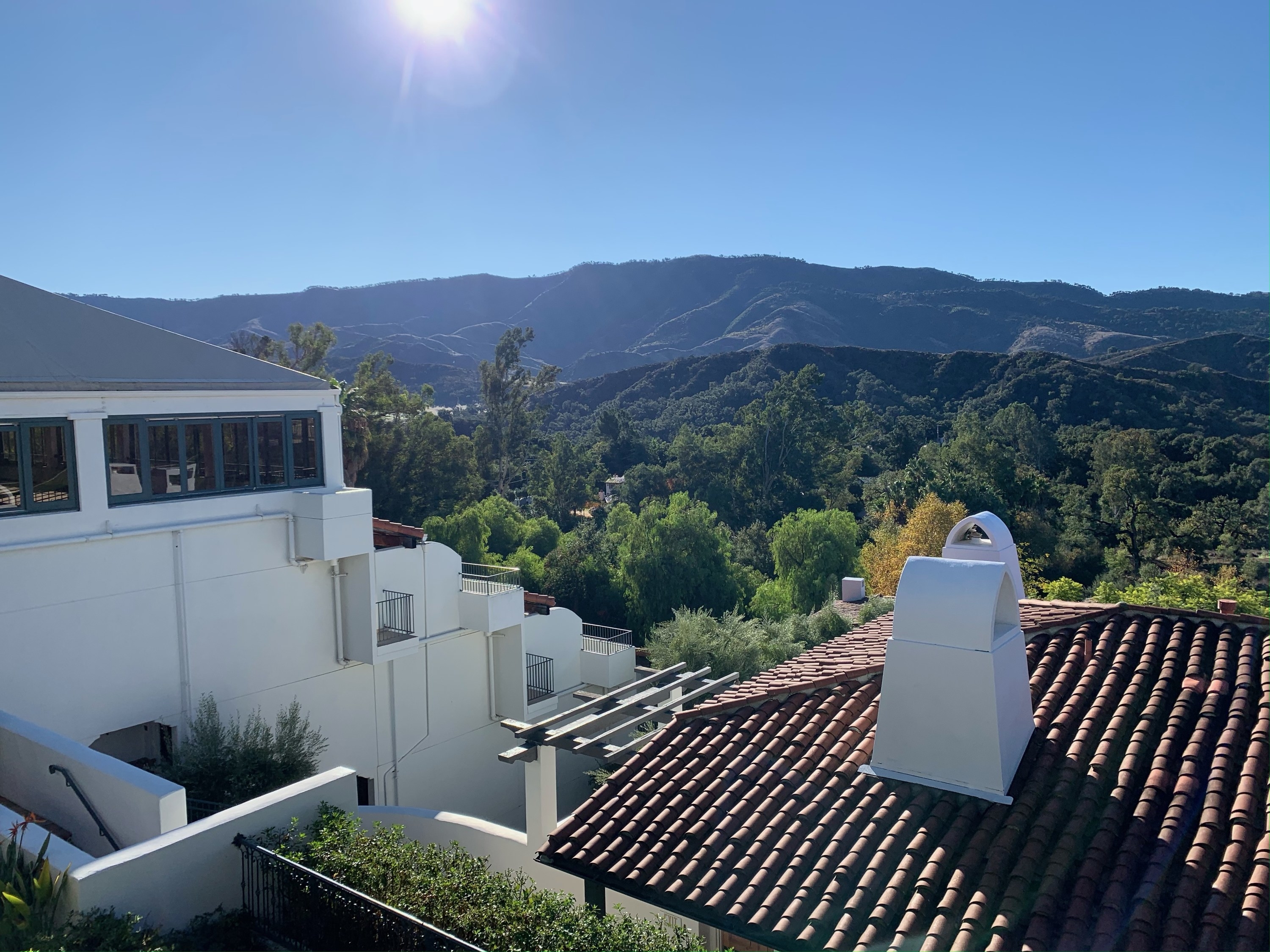 A view from one of the balconies at the resort, overlooking Spanish-style rooftops and mountains covered in trees in the distance
