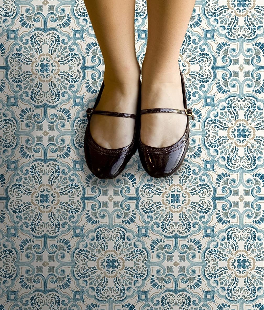 a top down view of the stick on tiles; someone&#x27;s mary jane shoes are visible at the top of the frame