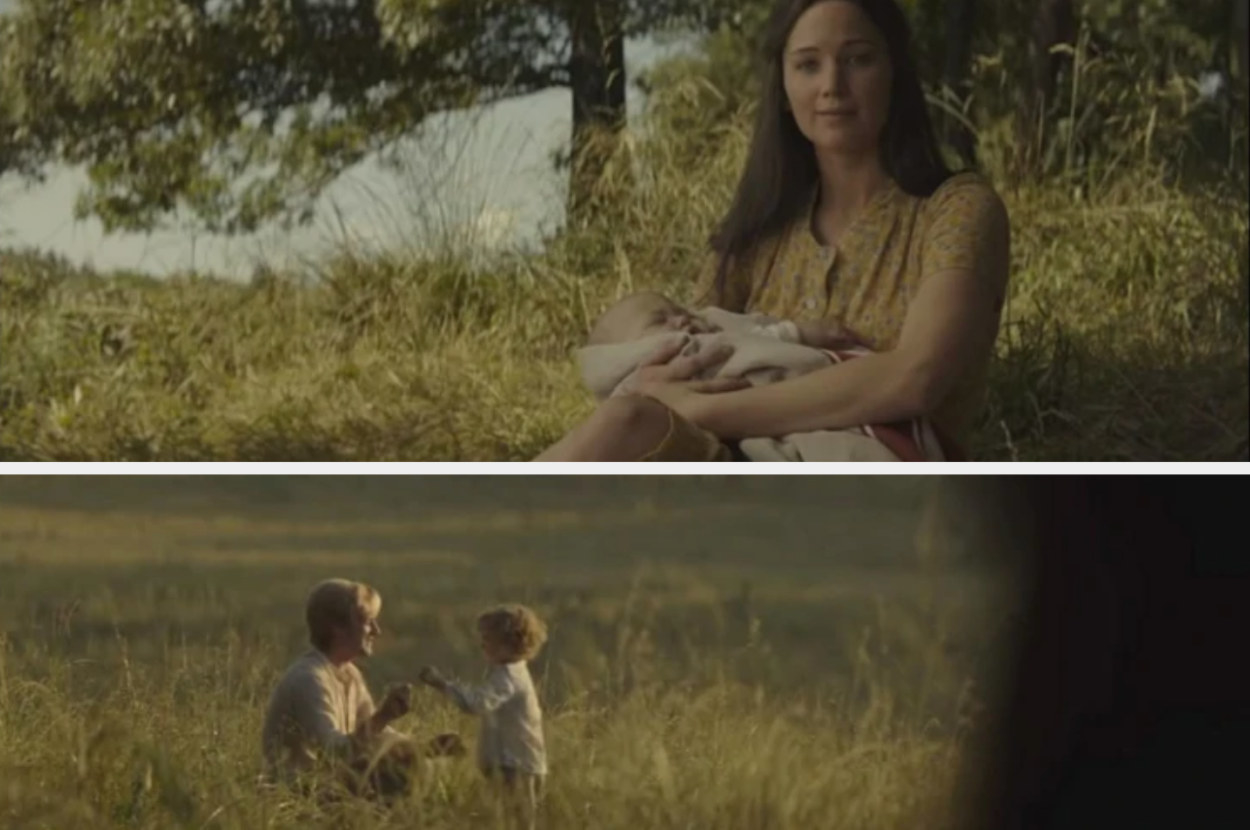 Katniss holding a baby while sitting on the grass