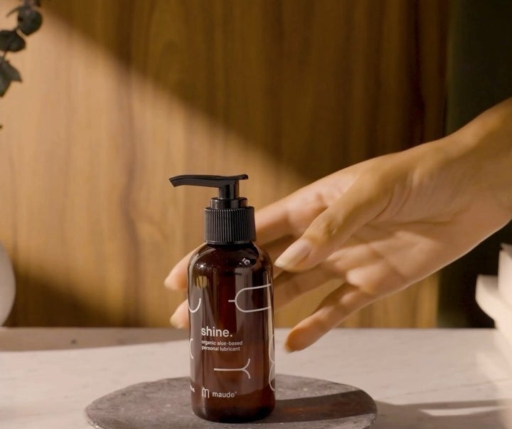 someone reaching for a bottle of the aloe-based lubricant