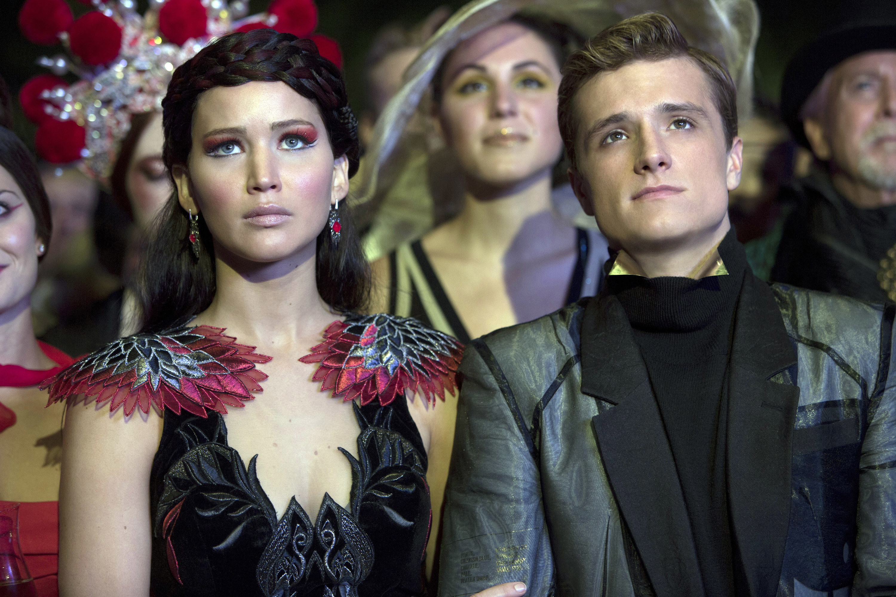Katniss and Peeta in a crowd looking up
