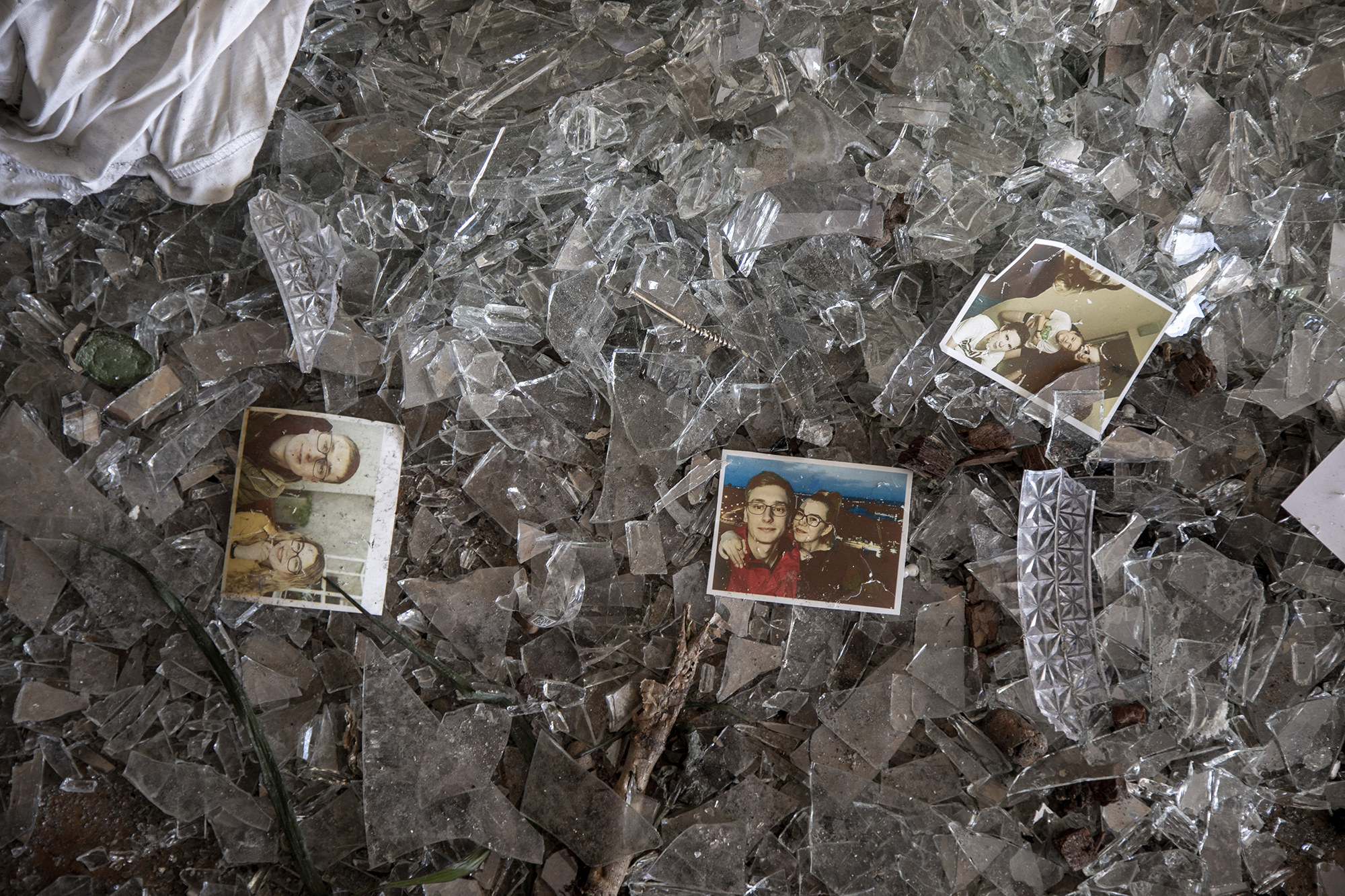 Portrait photos of a couple are seen scattered on a floor covered in debris in an apartment damaged by a bombing in Kyiv