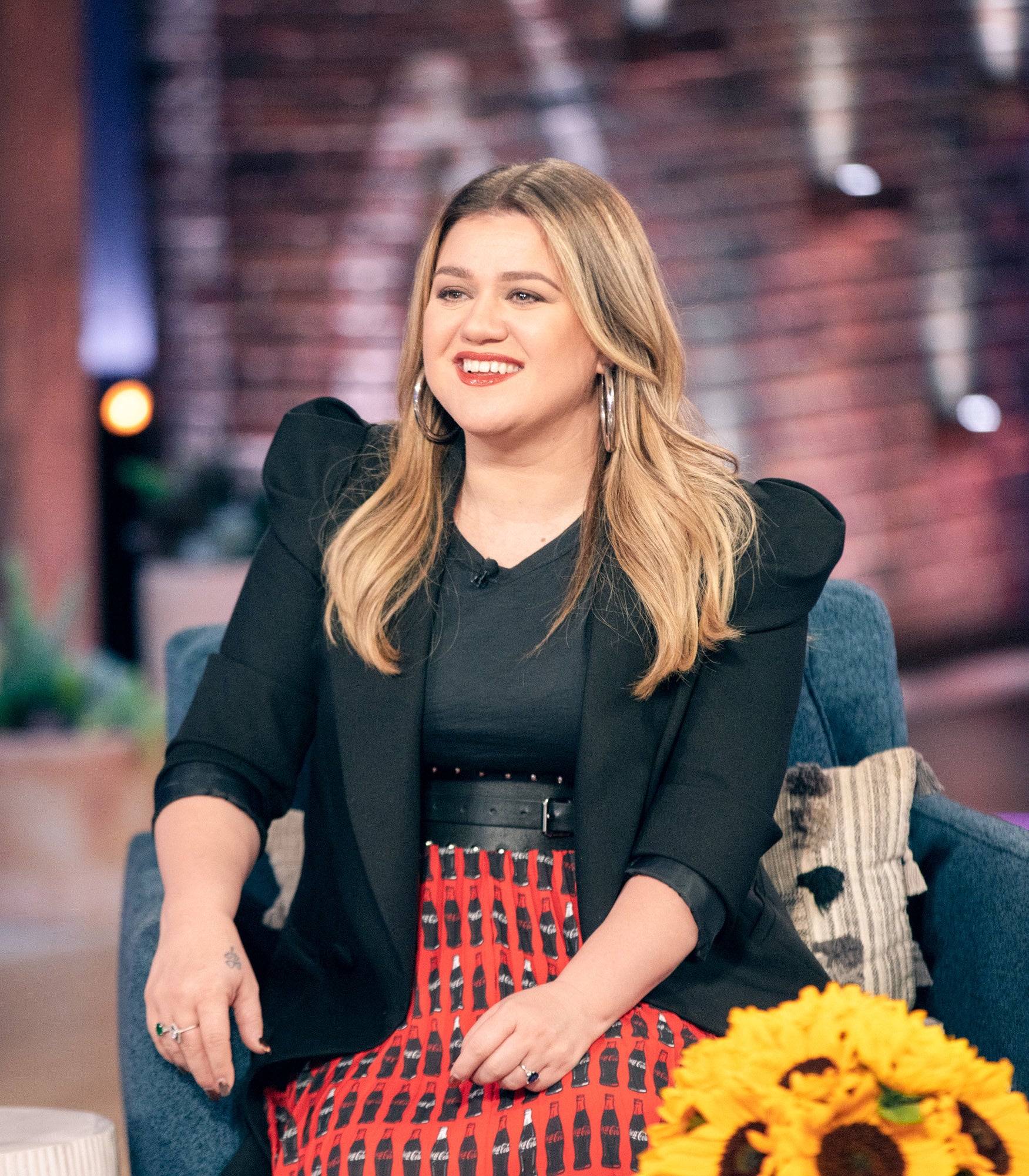 Kelly Clarkson sitting and talking on the set of her talk show