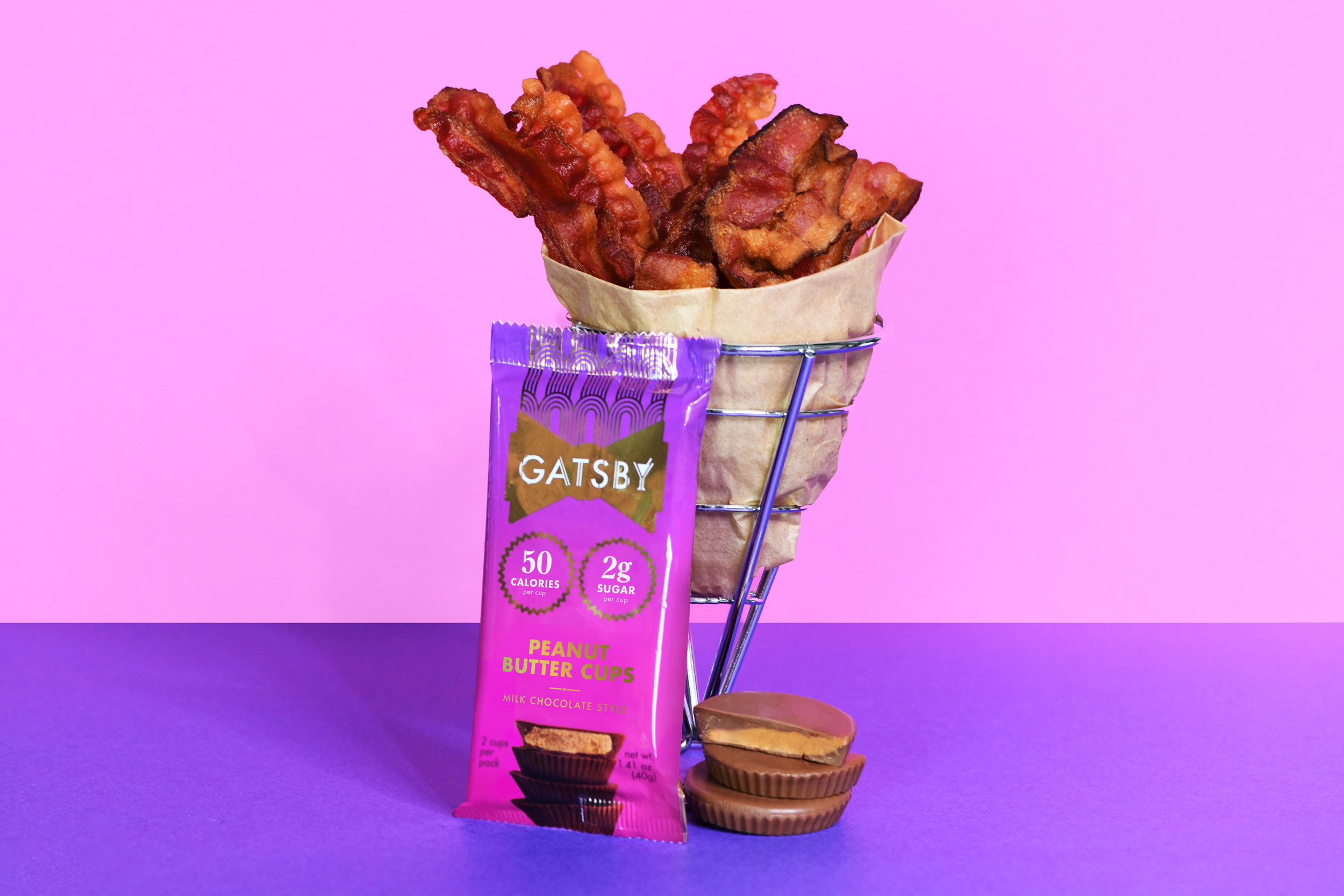 A package of peanut butter cups set beside a basket filled with bacon