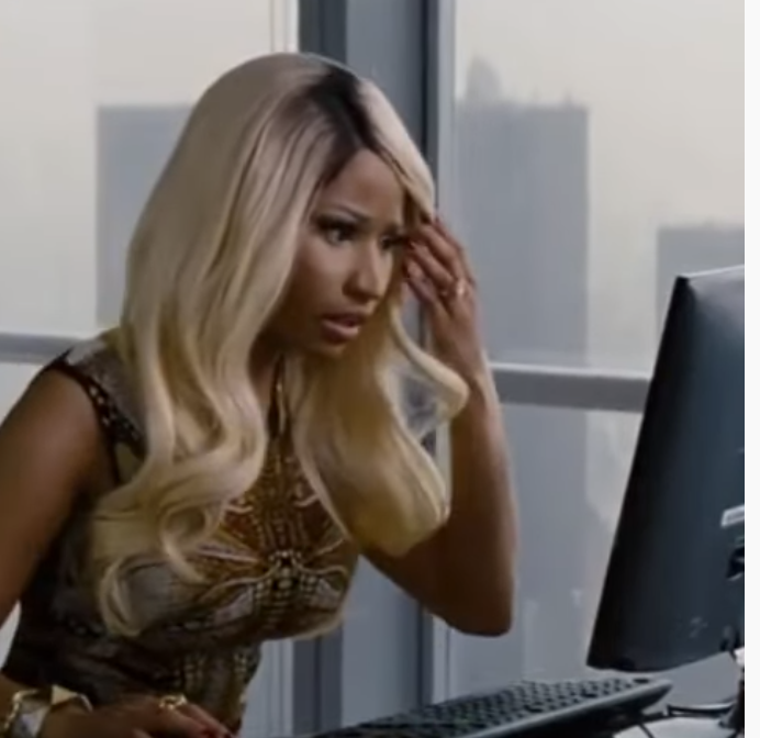 Nicki Minaj looking at a computer screen in disbelief