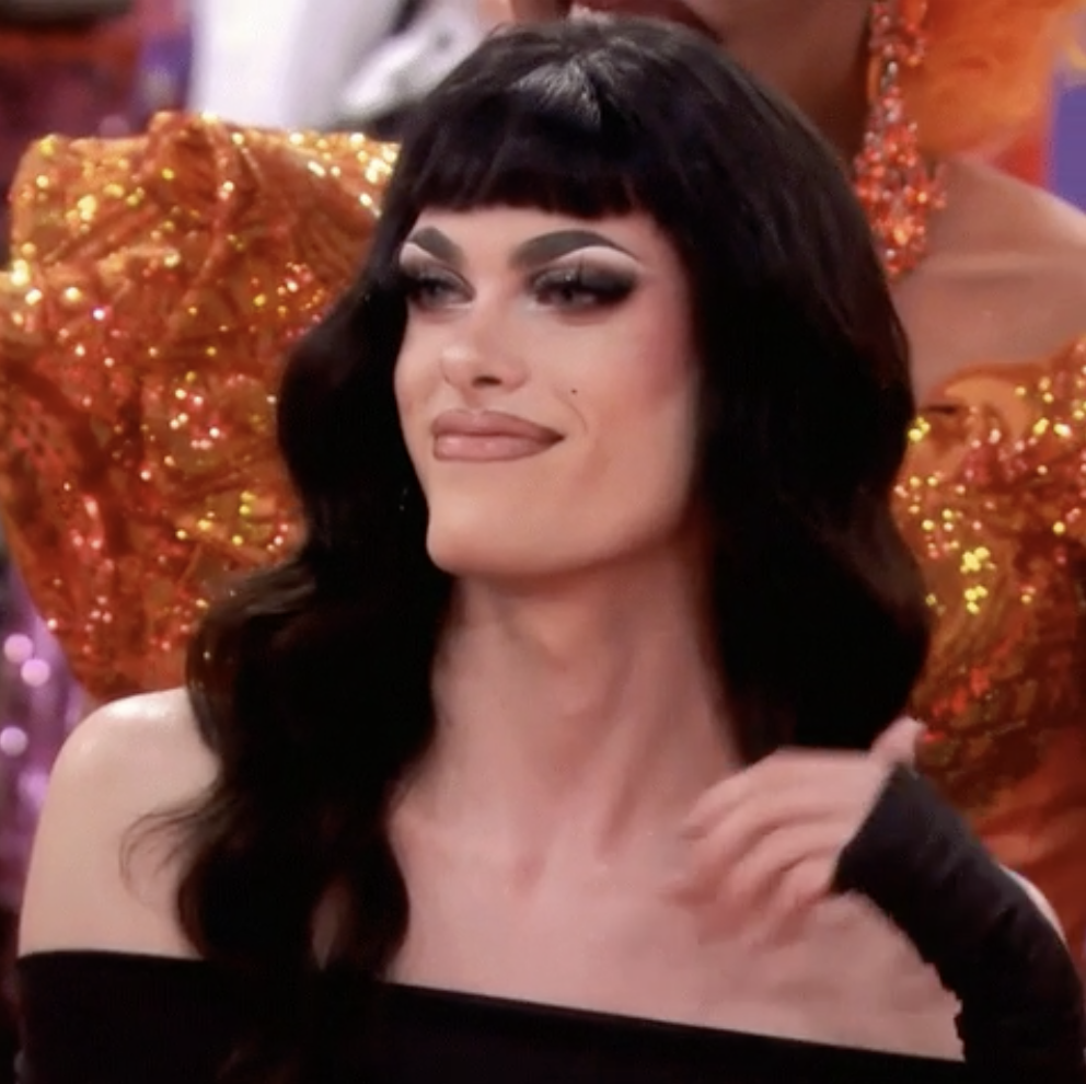 a drag queen smirks as she&#x27;s about to flip her hair