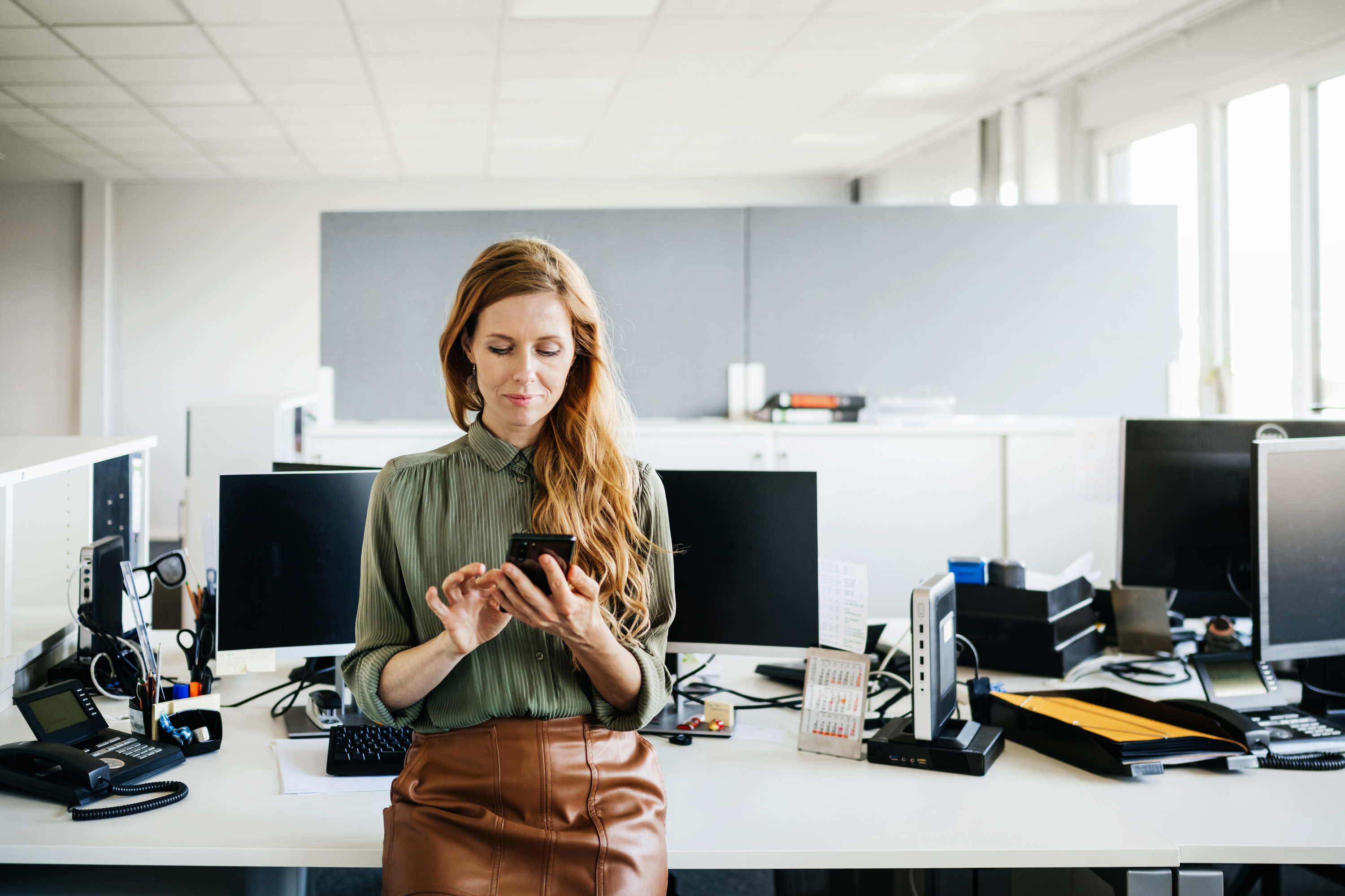 Young woman looking at her smartphone in an office