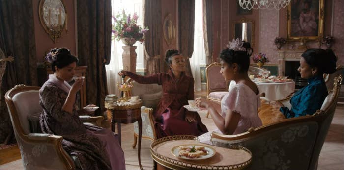 Lady Danbury, Mary Sharma, Edwina Sharma, and Kate Sharma sitting together, drinking tea.