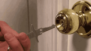 person using a lockpick on a doorknob