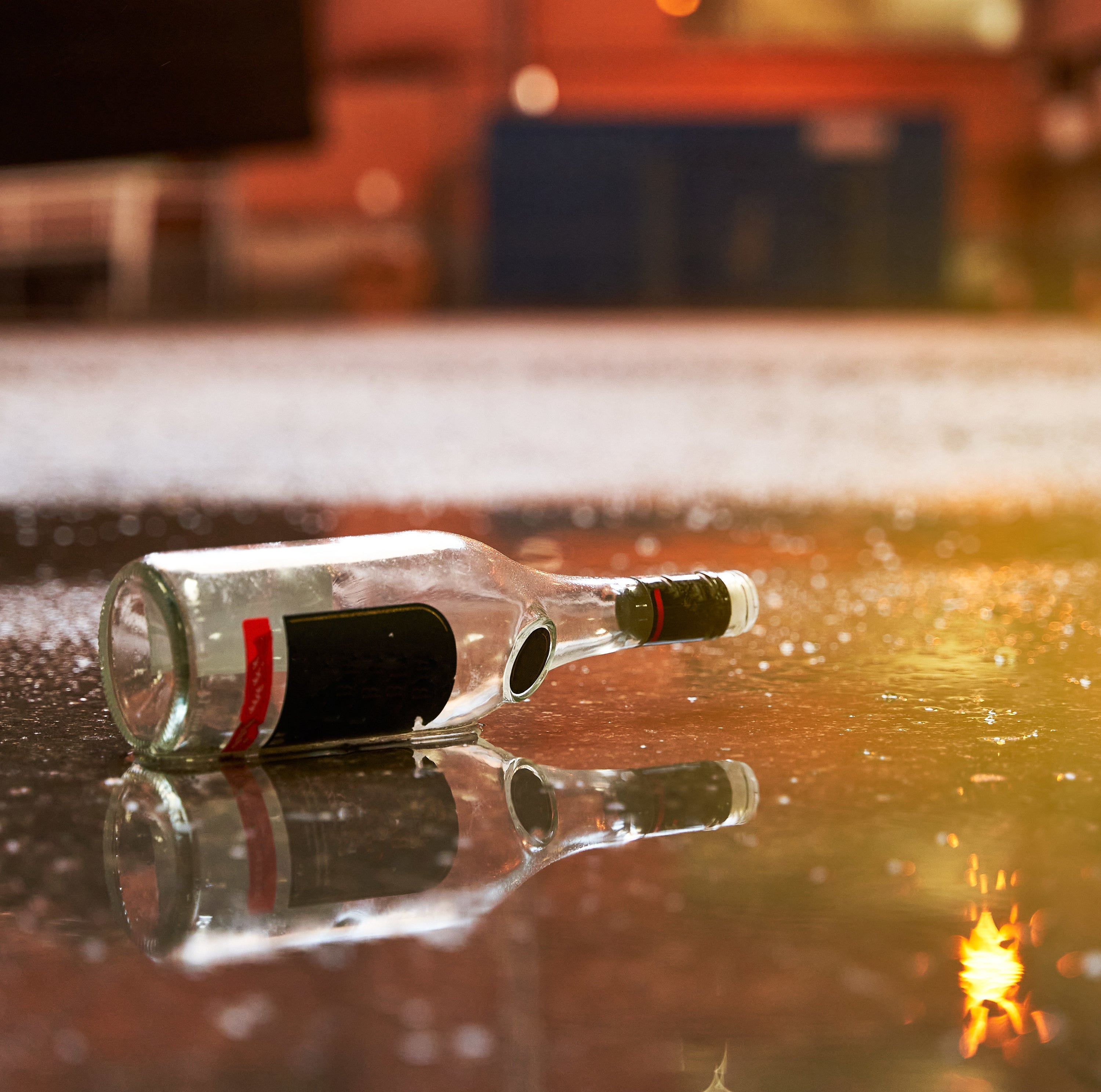 Garbage after-party in the street concept. Empty alcohol bottle on the floor at campus during sunset
