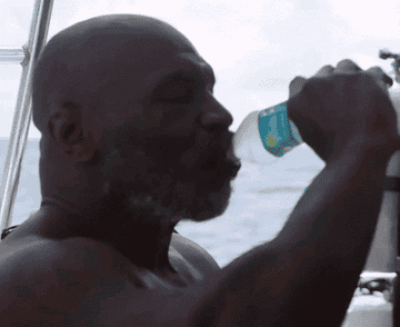 Mike Tyson drinking and crushing a water bottle