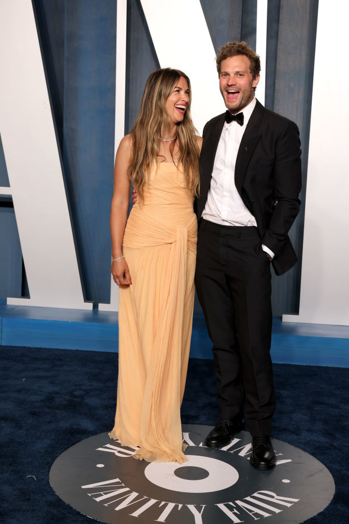 Amelia in a light-colored, floor-length gown smiling at Jamie in a bow tie