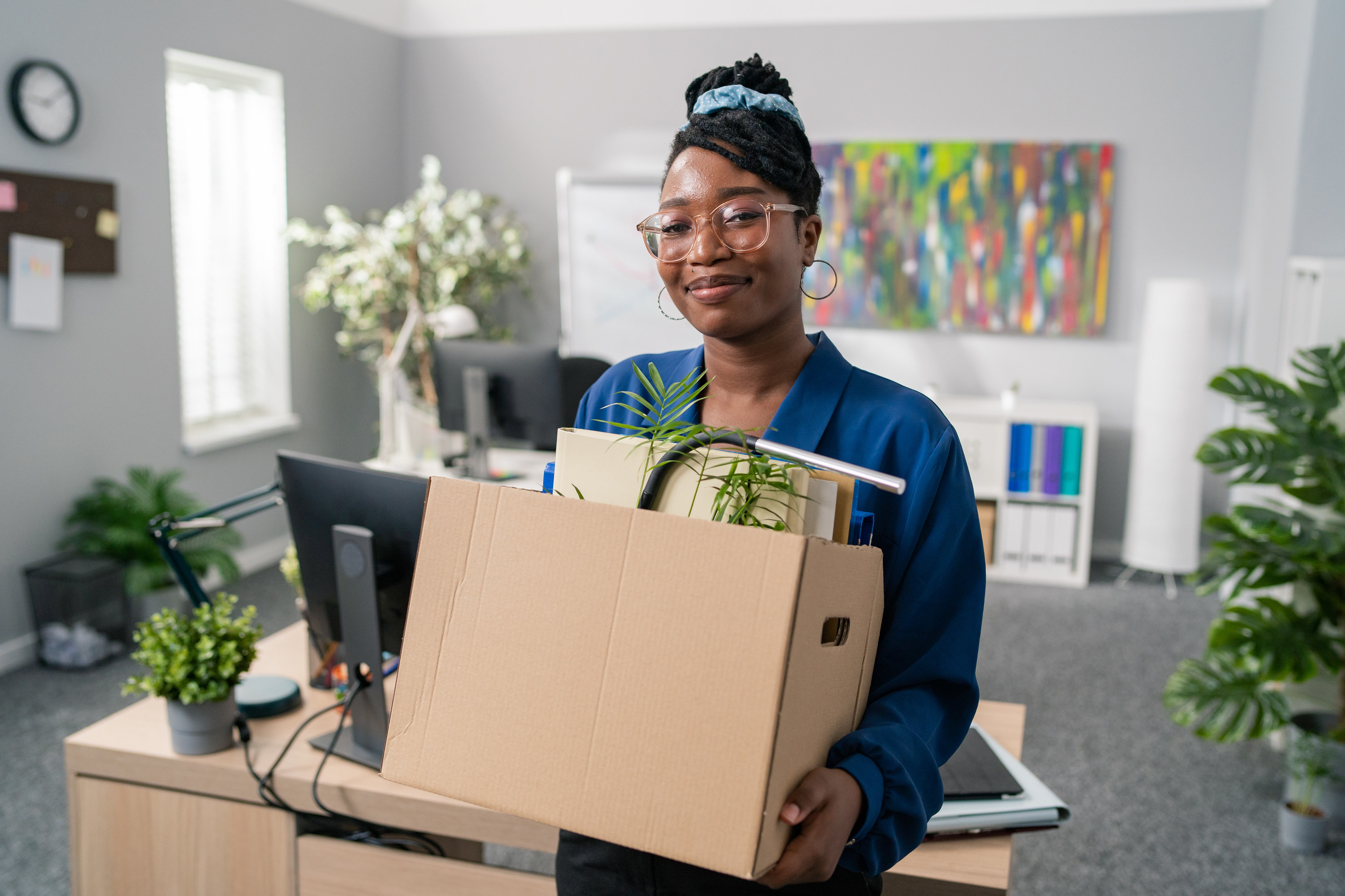 Woman with box of items leaving an office