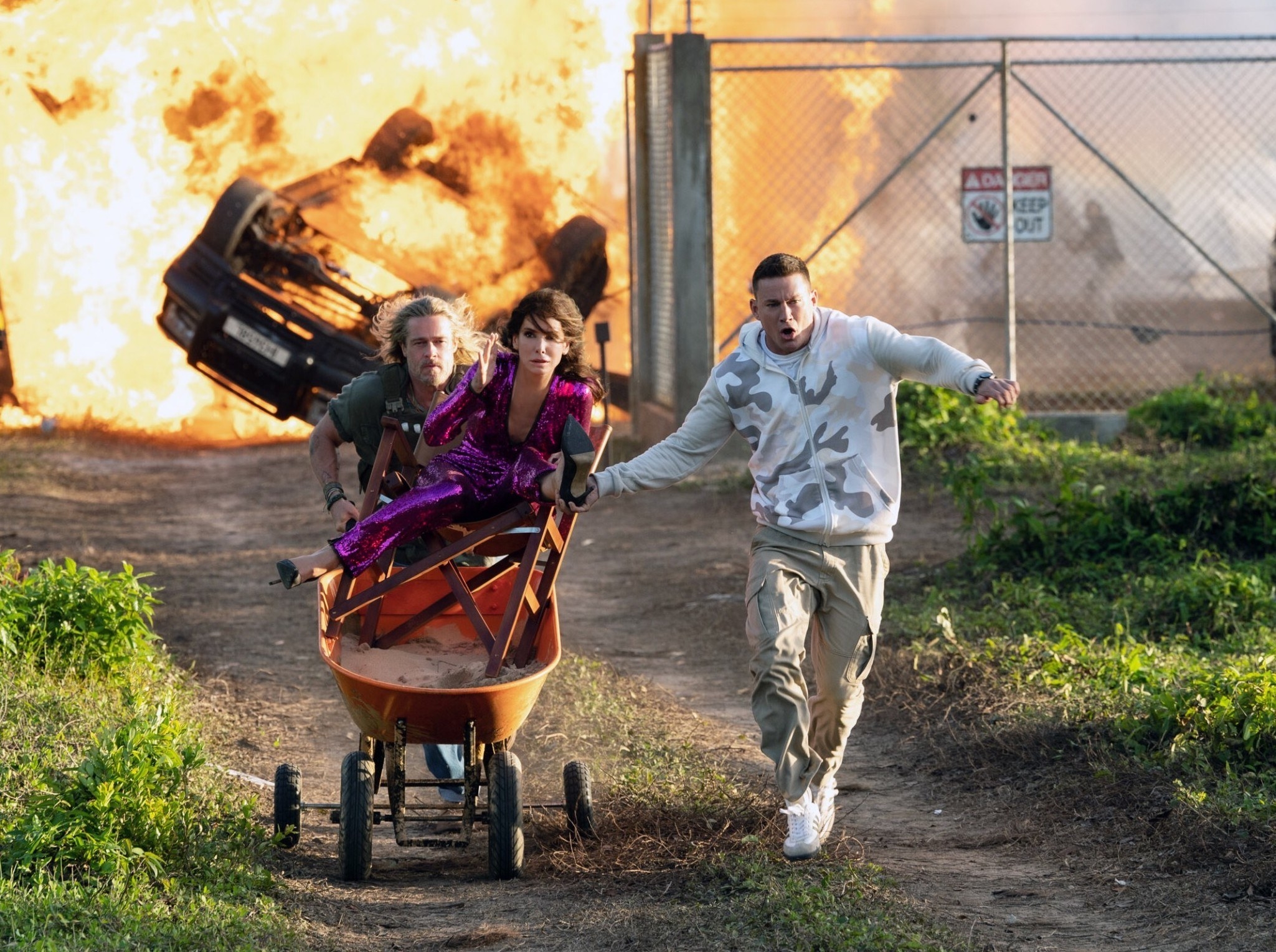 Brad Pitt, Sandra Bullock, and Channing Tatum running from an explosion in The Lost City