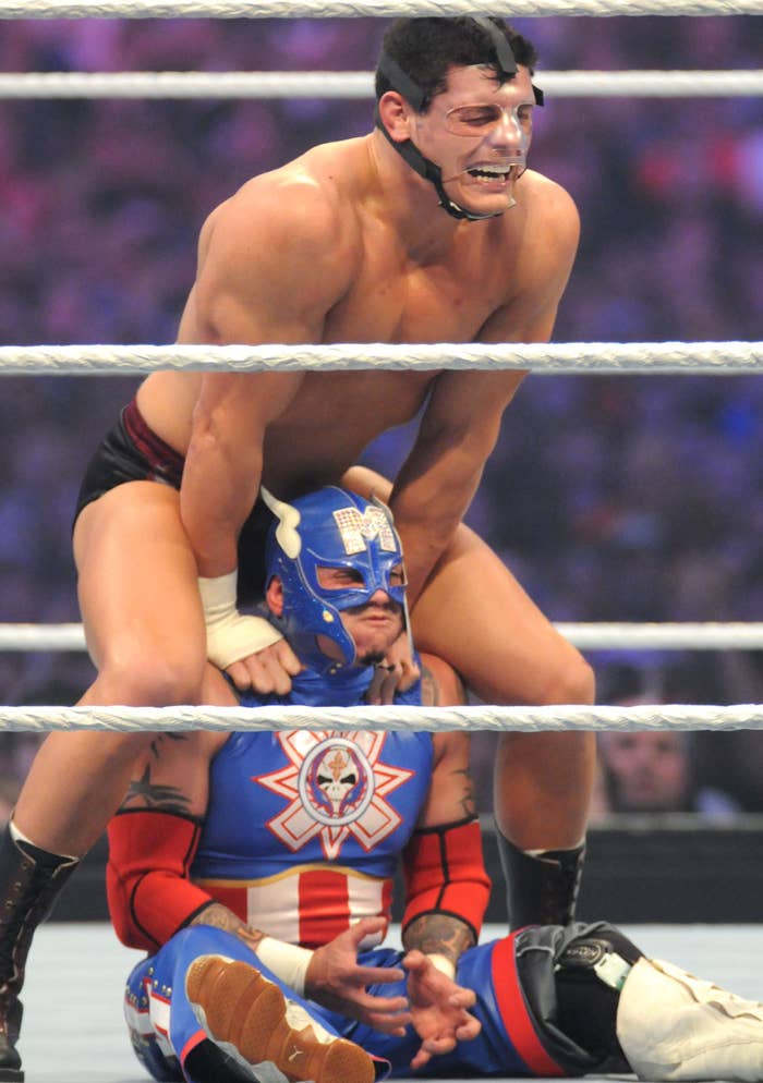 Cody Rhodes applying a submission hold on Rey Mysterio