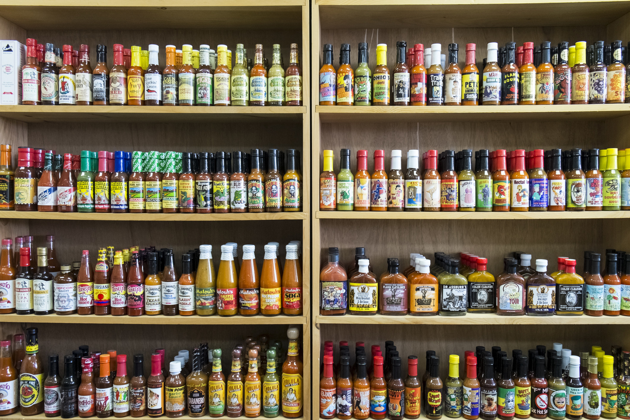 Shelves filled with many different hot sauces