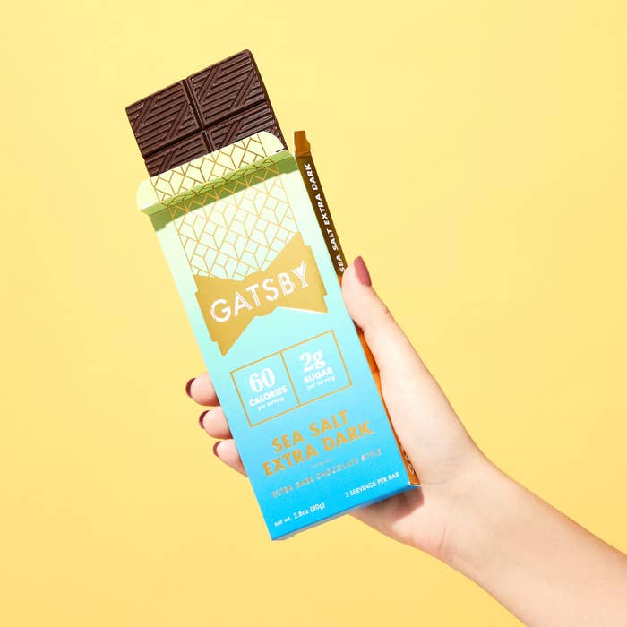 A hand holding an opened bar of Gatsby&#x27;s Sea Salt Extra Dark chocolate