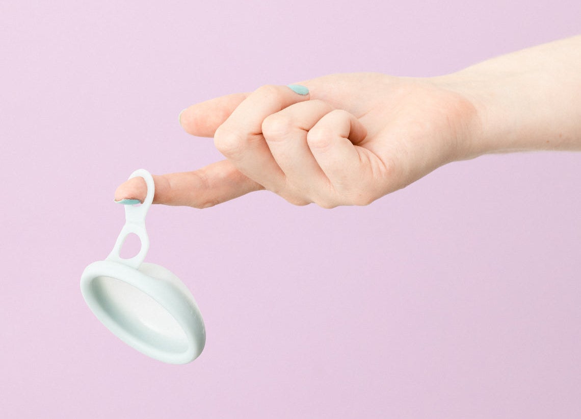 A person holding a menstrual disc but the double loop pull tab