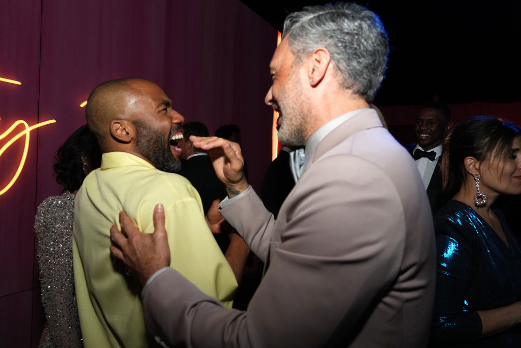 Donald laughing as a laughing Taika touches his shoulder