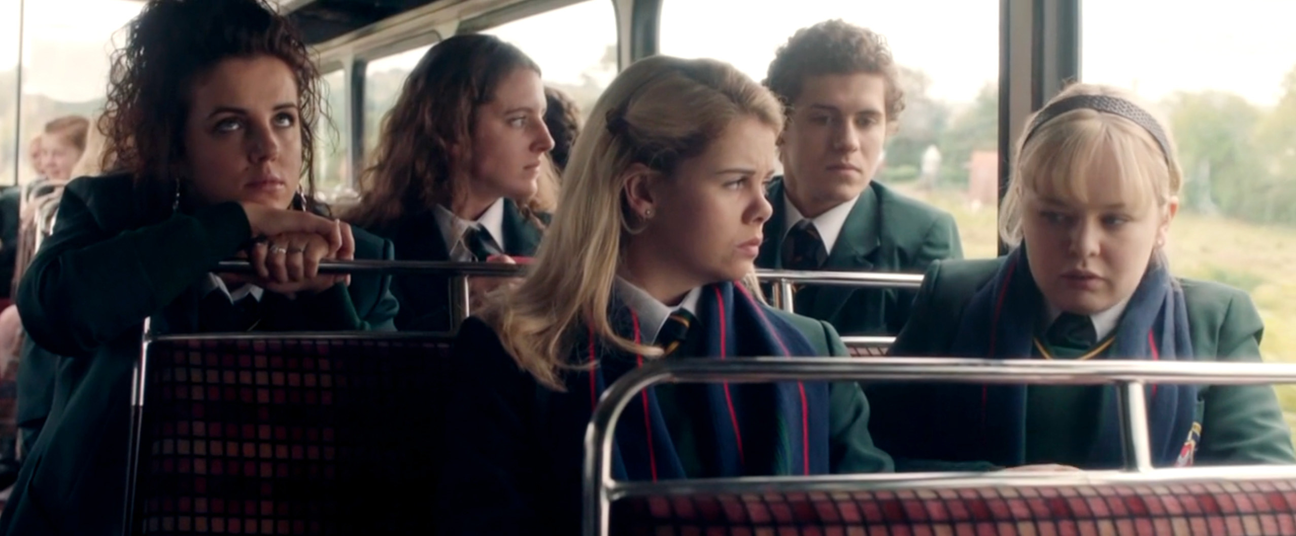 In a screenshot from the pilot, the show&#x27;s central five characters are on a bus to school, all in school uniform. From left to right sit Michelle, Orla, Erin, James and Clare.