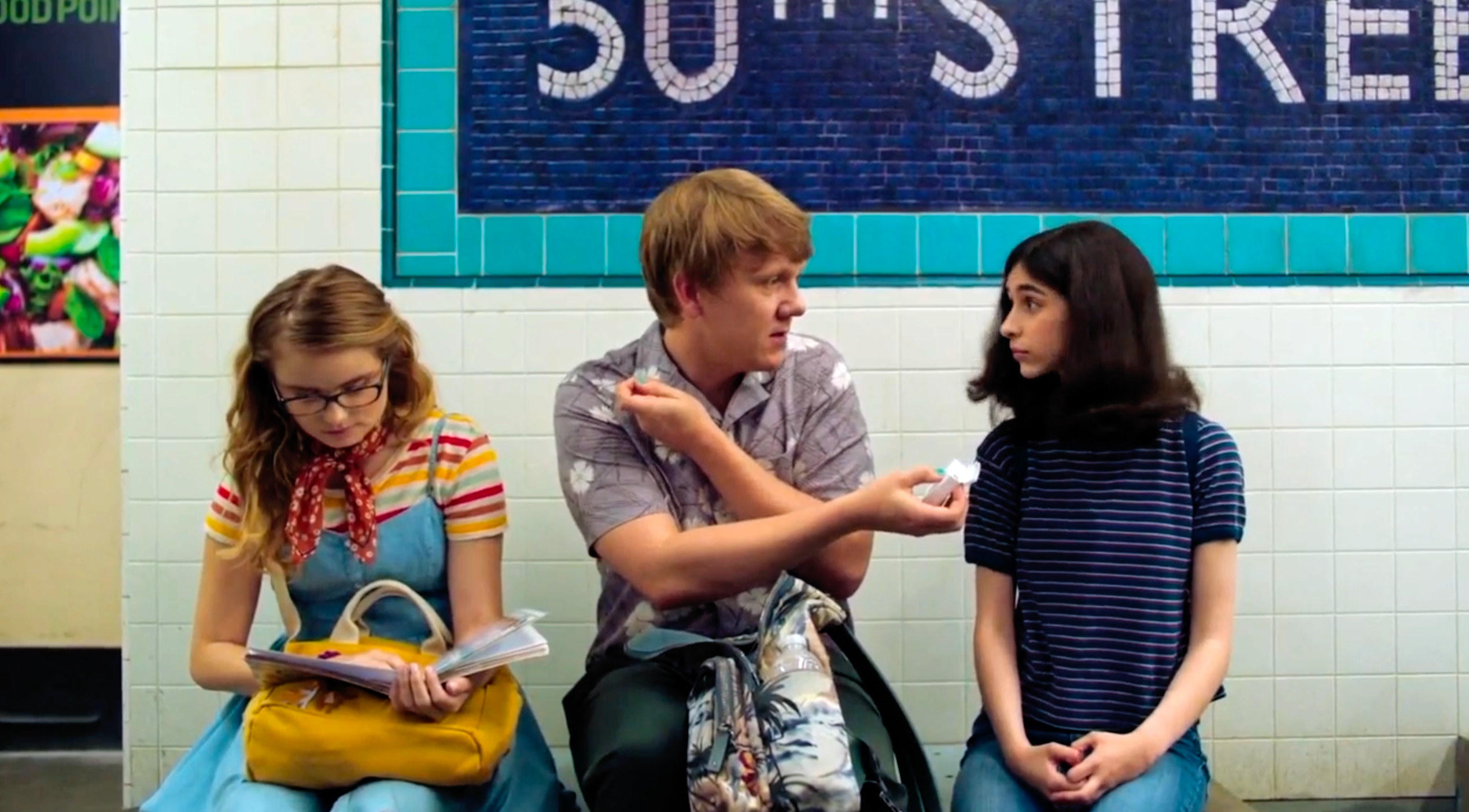 In a screenshot from the finale, the three siblings sit on a bench in a subway station in New York. From left to right are Matilda, Nicholas and Genevieve. Matilda is looking down at a book in her lap, and Nicholas is offering Genevieve dental floss.