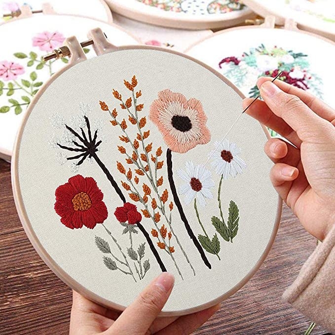 A person working on their floral embroidery kit