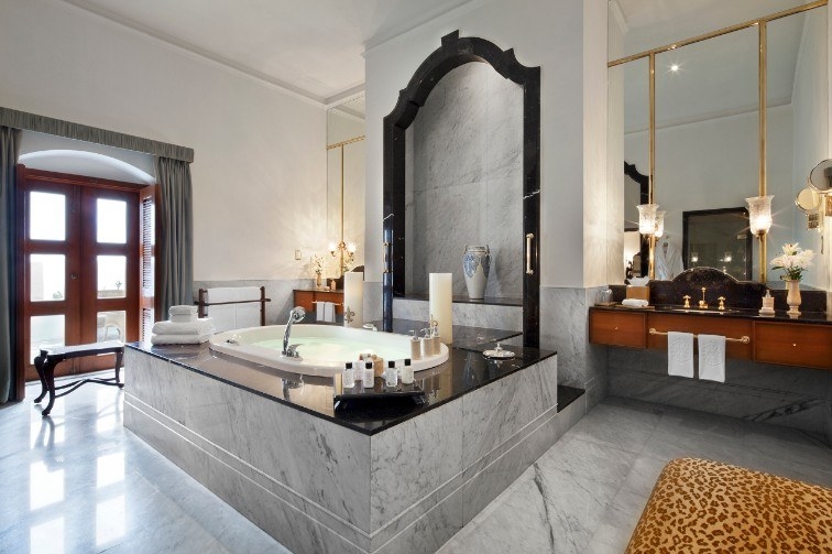 A grand bathroom in one of the hotel&#x27;s suites, featuring a large marble bathtub