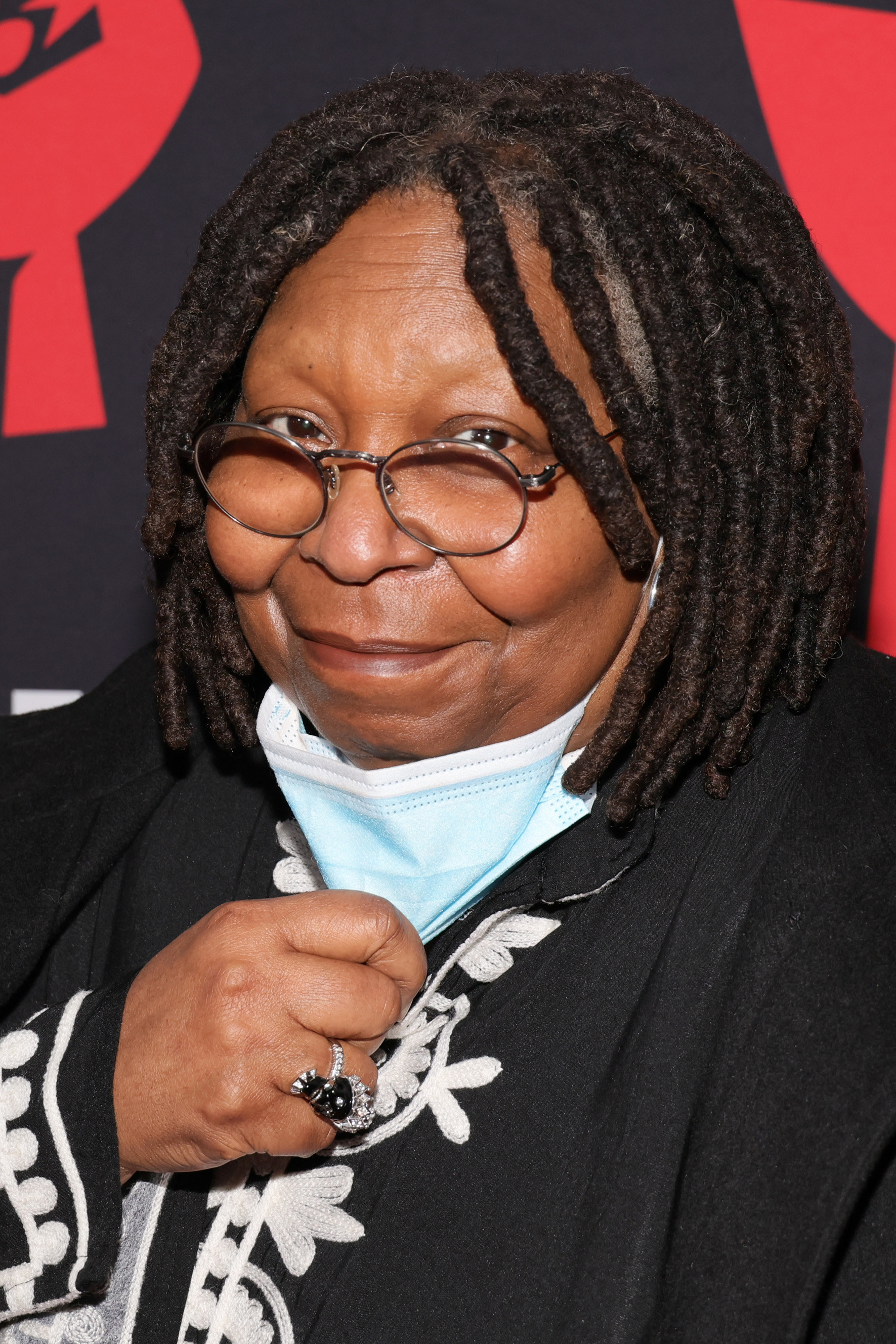 Whoopi pulling her face mask down for a photo