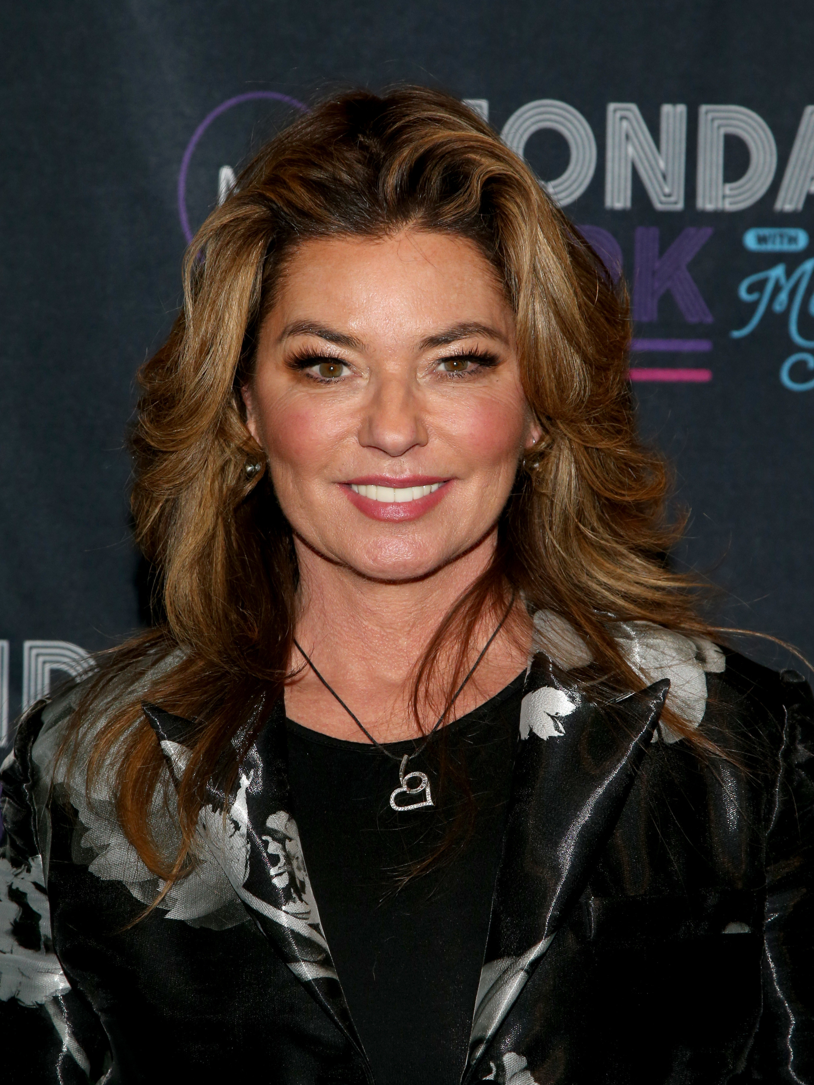 Shania wearing a dark floral suit at an event