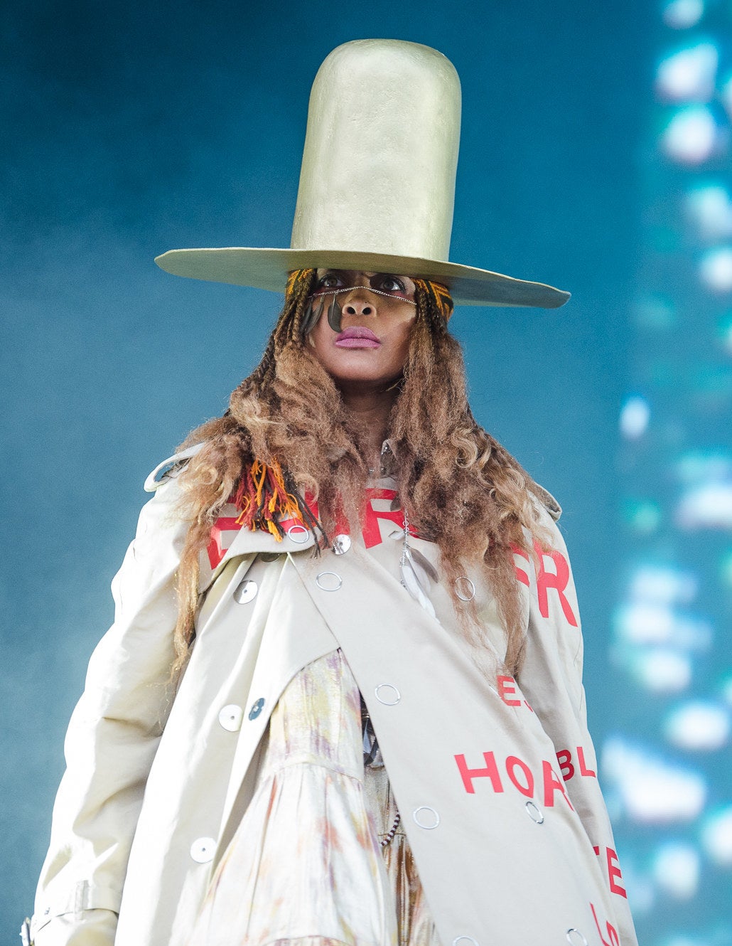 Erykah wearing a tall top hat on stage