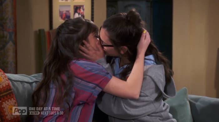 A screenshot of Elena Alvarez and her partner, Syd in the season 4 premiere of the show. The two are in the living room of the apartment, kissing. Syd has one arm around Elena with their hand in her hair, and Elena has Syd&#x27;s face in her hands.