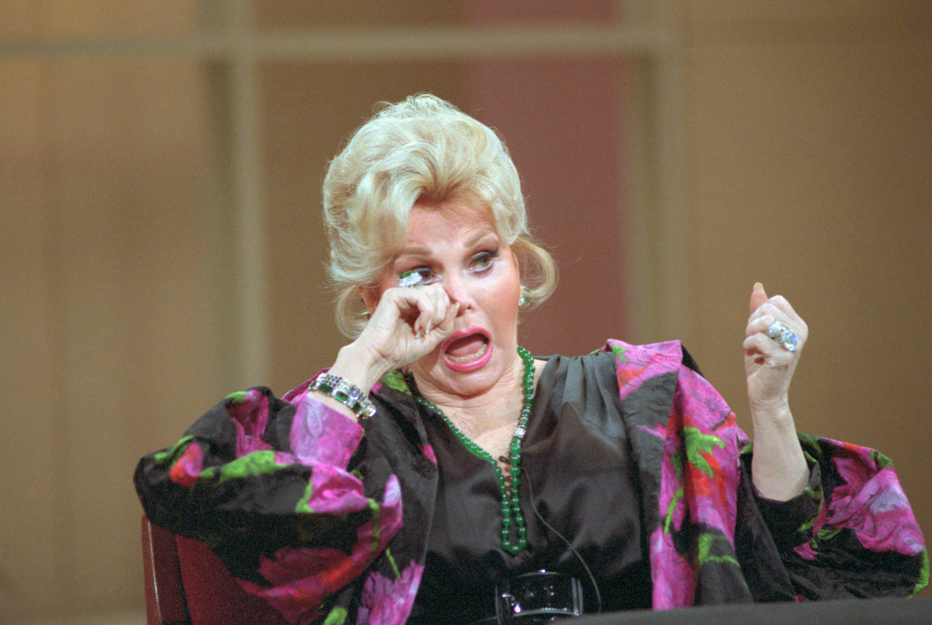 Zsa Zsa Gabor dabs at her eye as she appears on the Donahue Show
