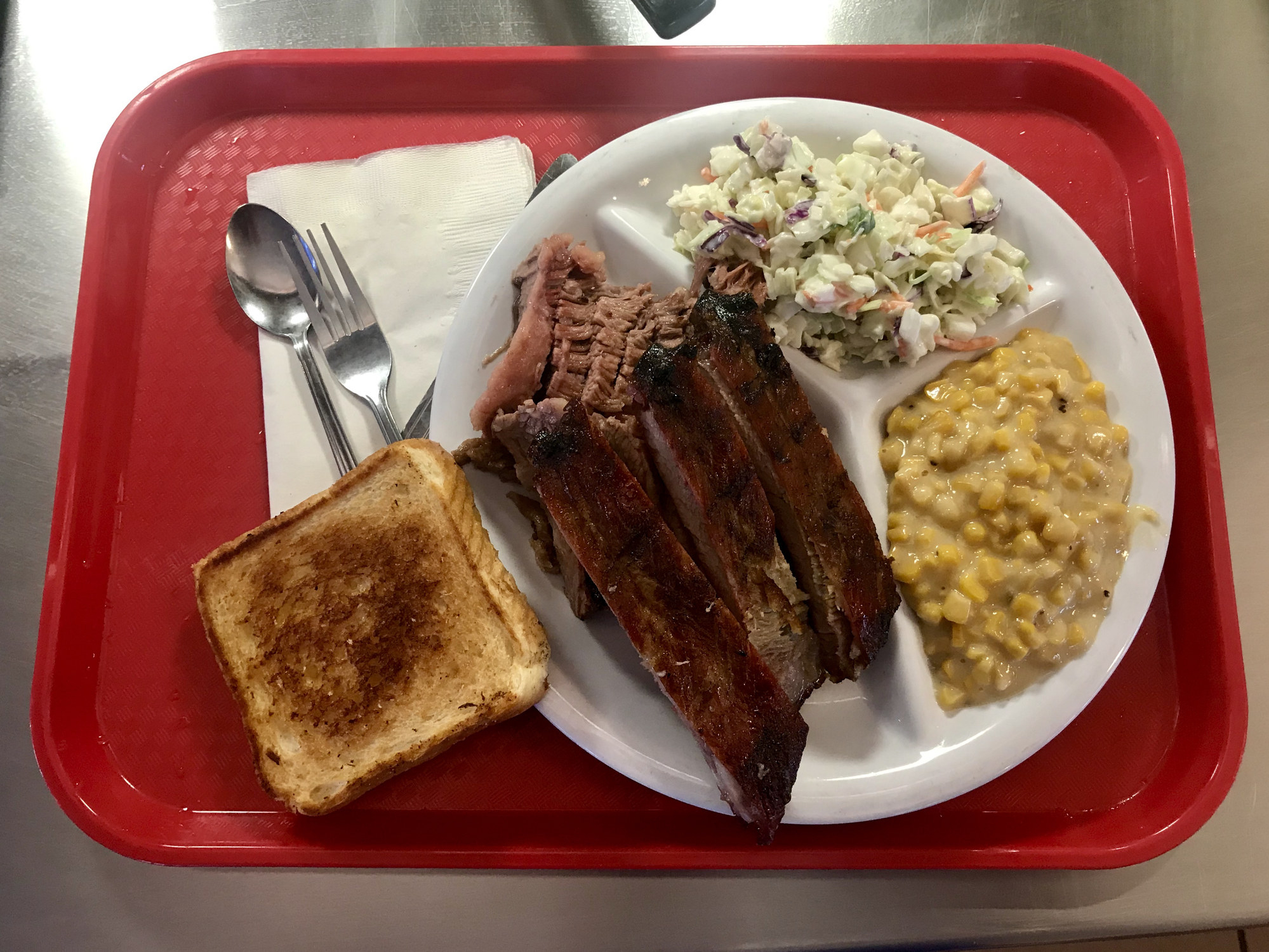 A tray with a plate of Texas barbecue and sides