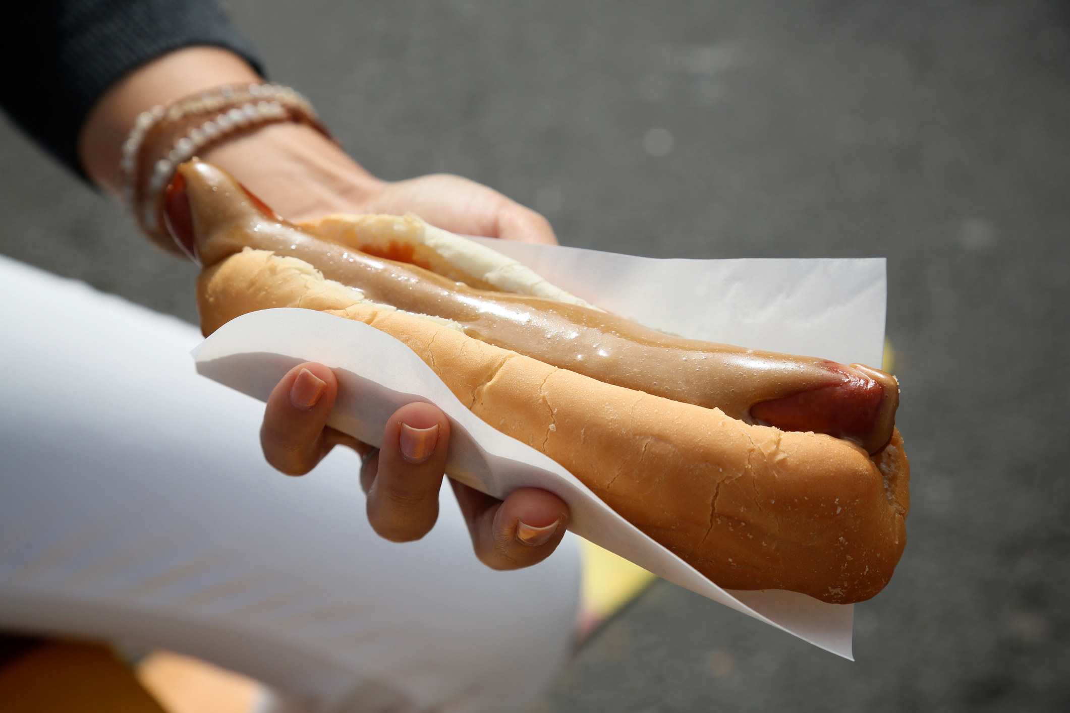 A hand holding an Icelandic hot dog.