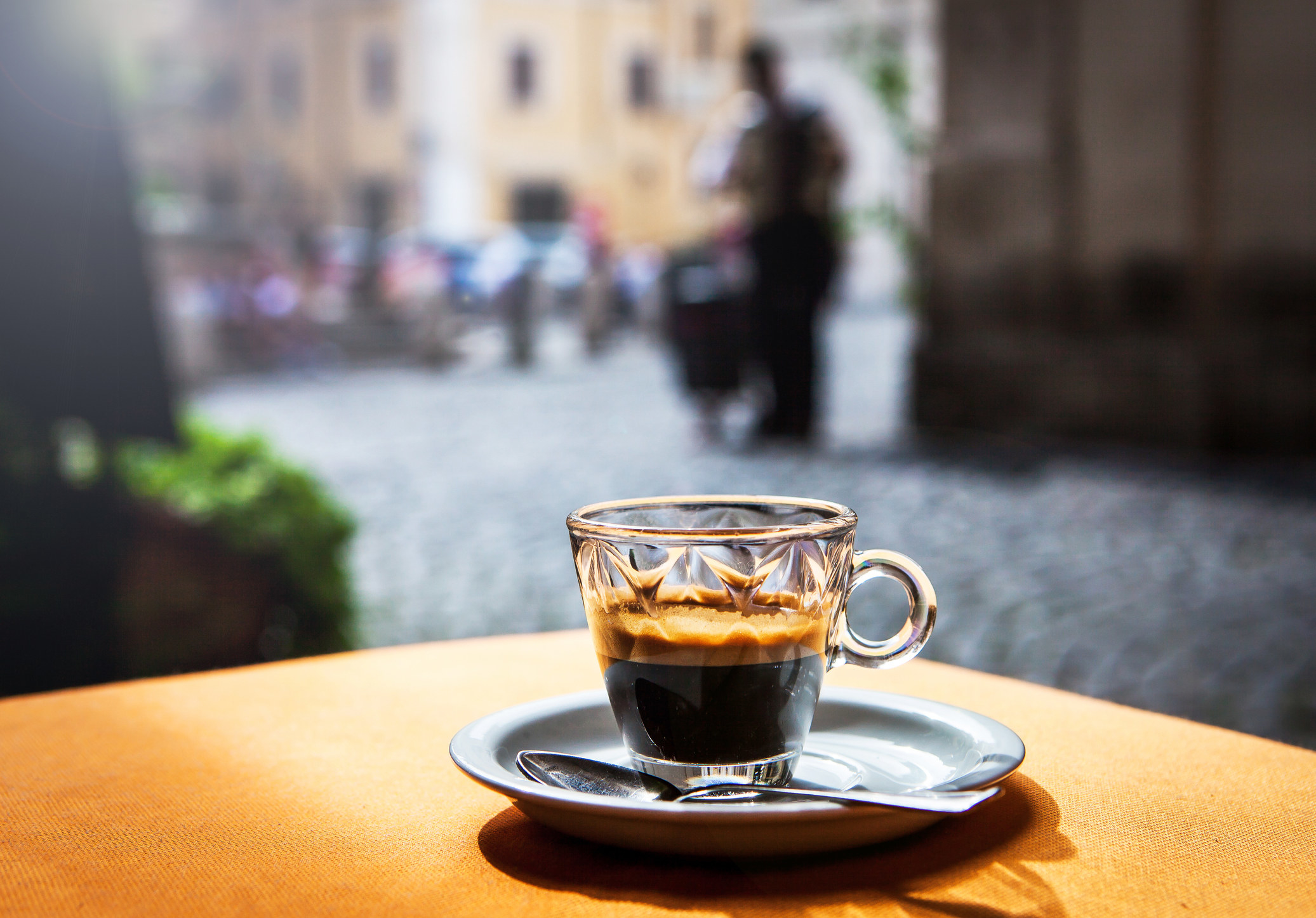 A cut of espresso on a table outdoors.