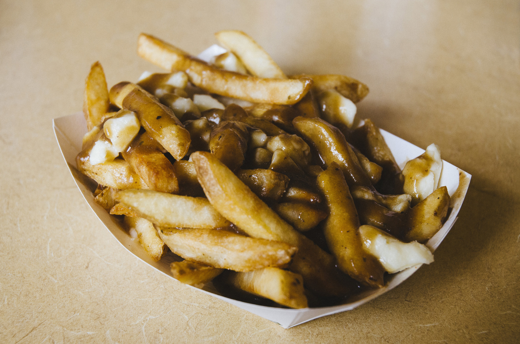 Poutine served in a takeaway plate.