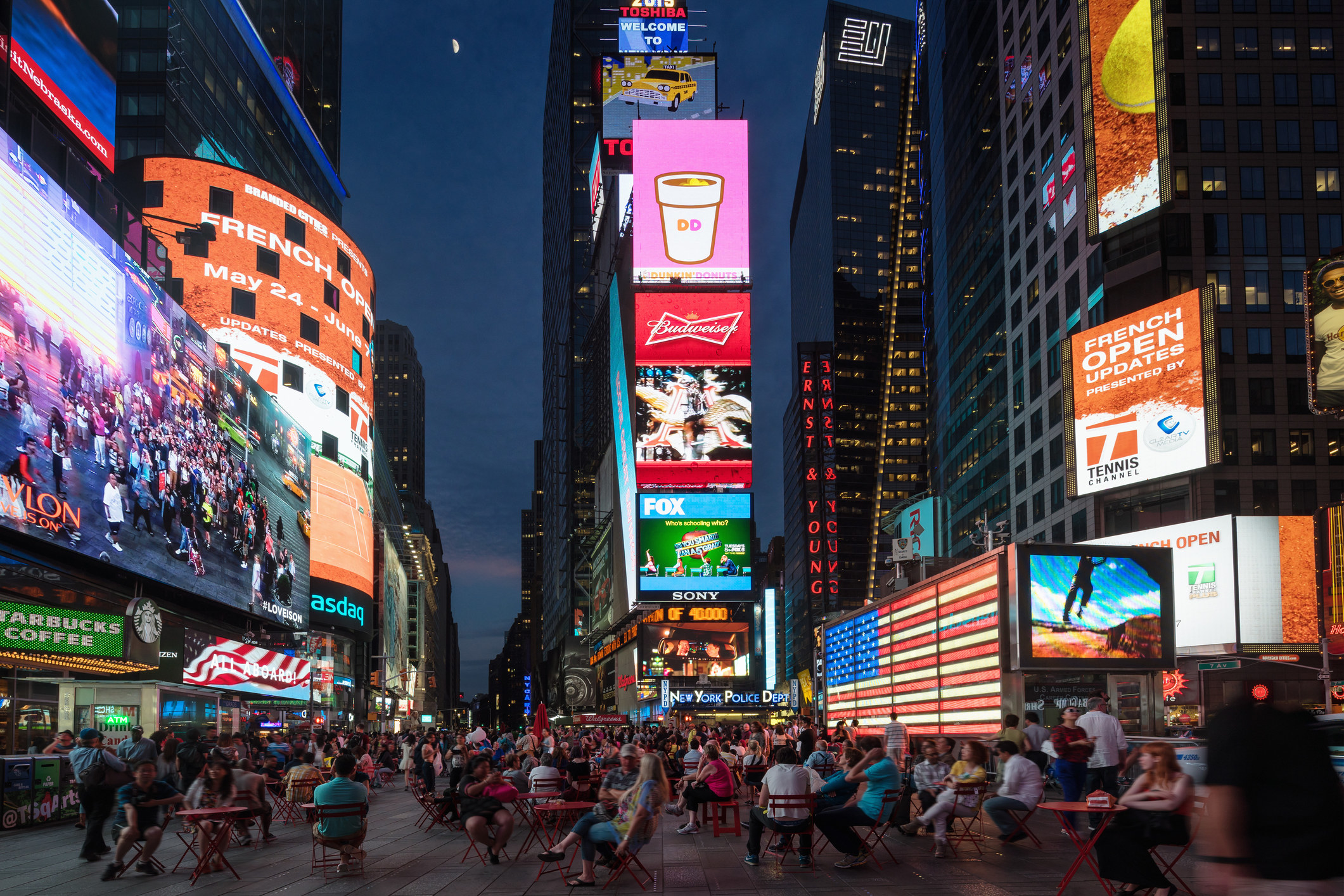 Billboards lit up in Times Square at dusk.