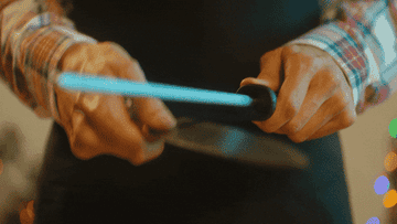 Hands sharpening a knife