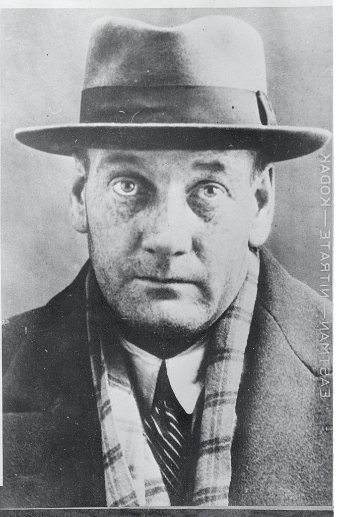 A black and white photo of a man in a fedora