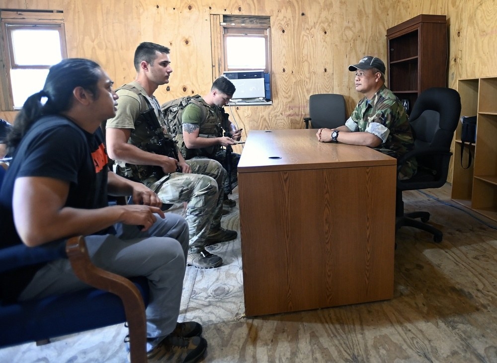 Four soldiers having a discussion around a desk