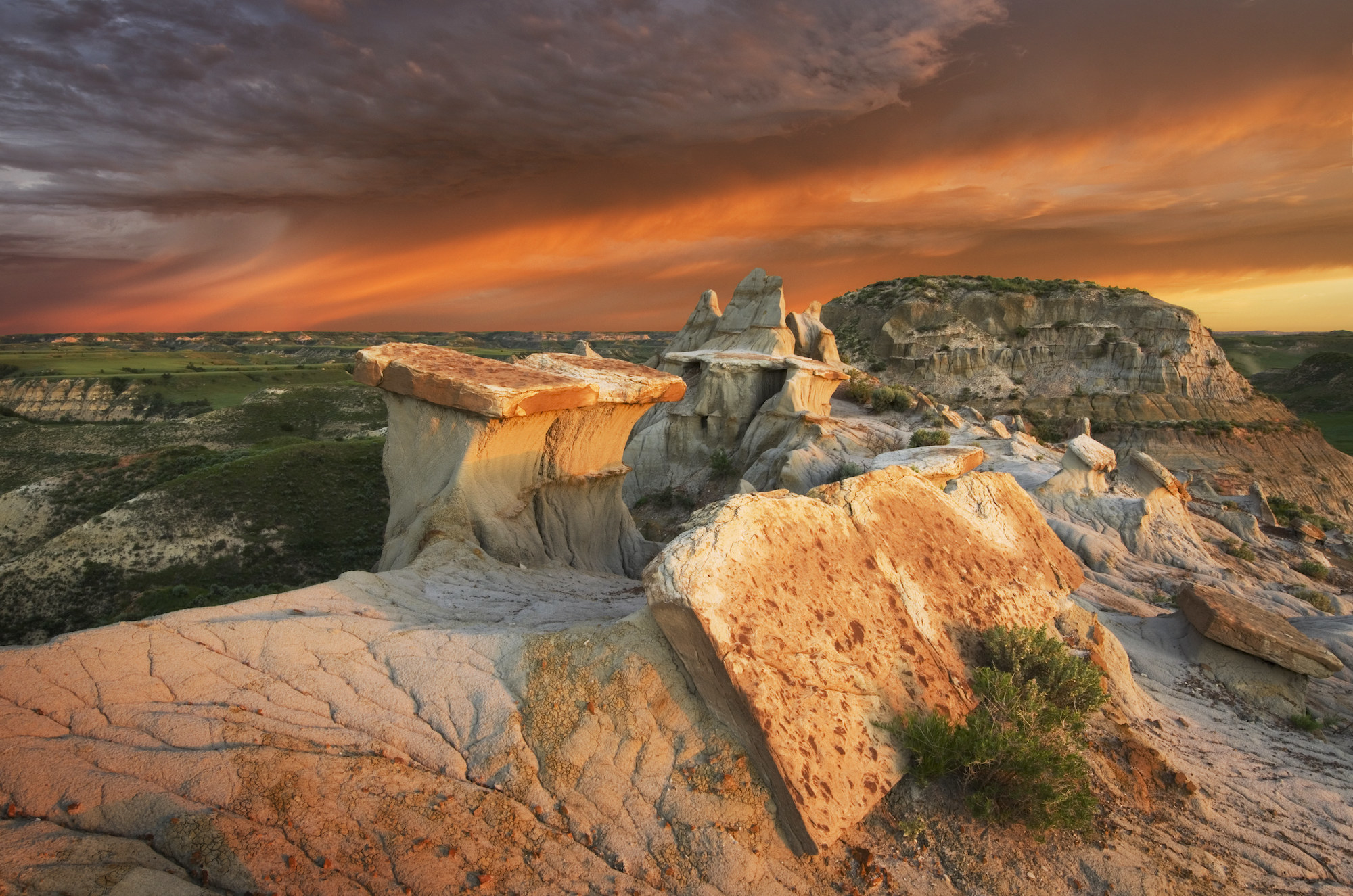 Clearing storm at sunrise over badlands sandstone formations,