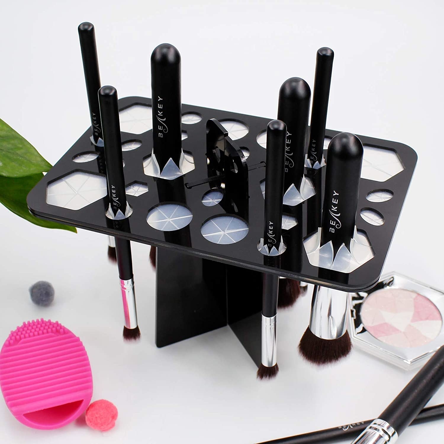 Brushes hanging in the brush holder on a table surrounded by cosmetic items