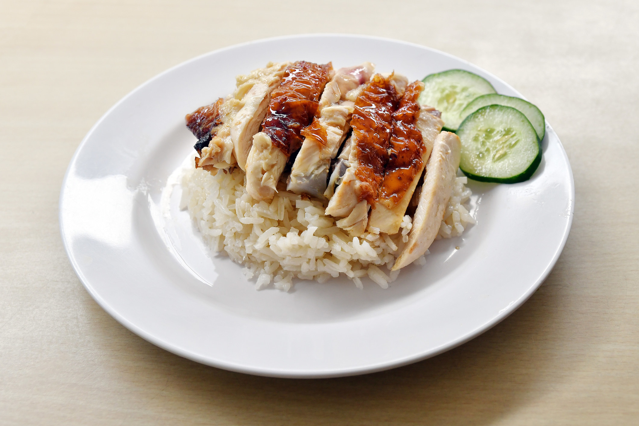 Singaporean chicken rice with cucumbers and spicy sauce.