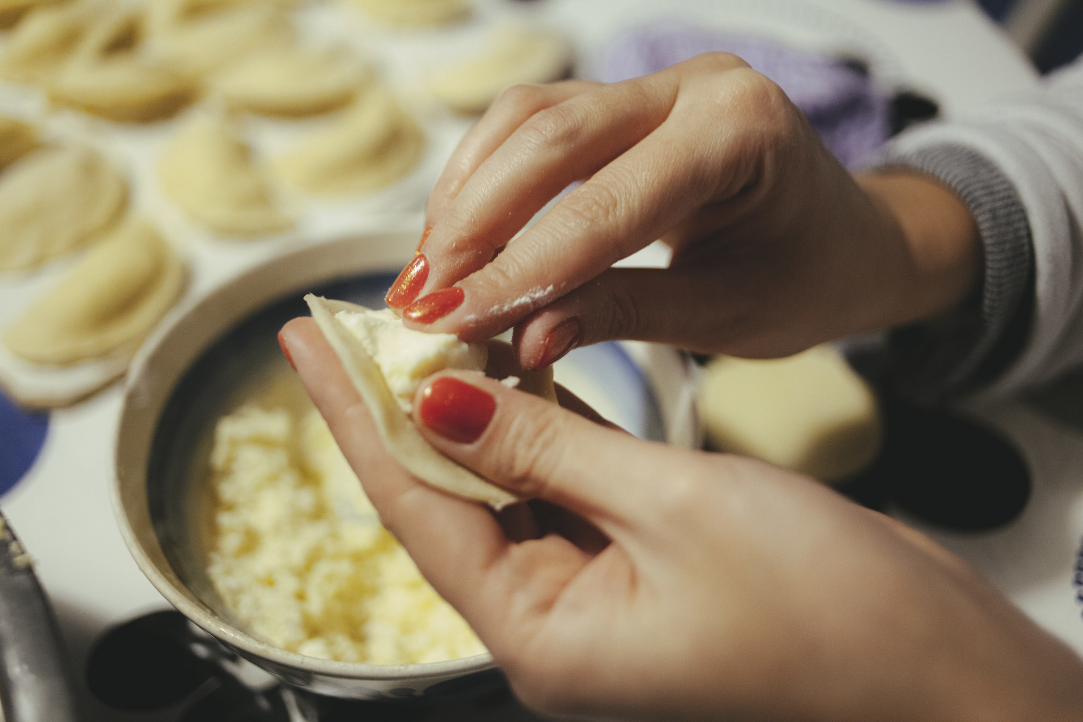 A woman making a Ukranian dumpling.