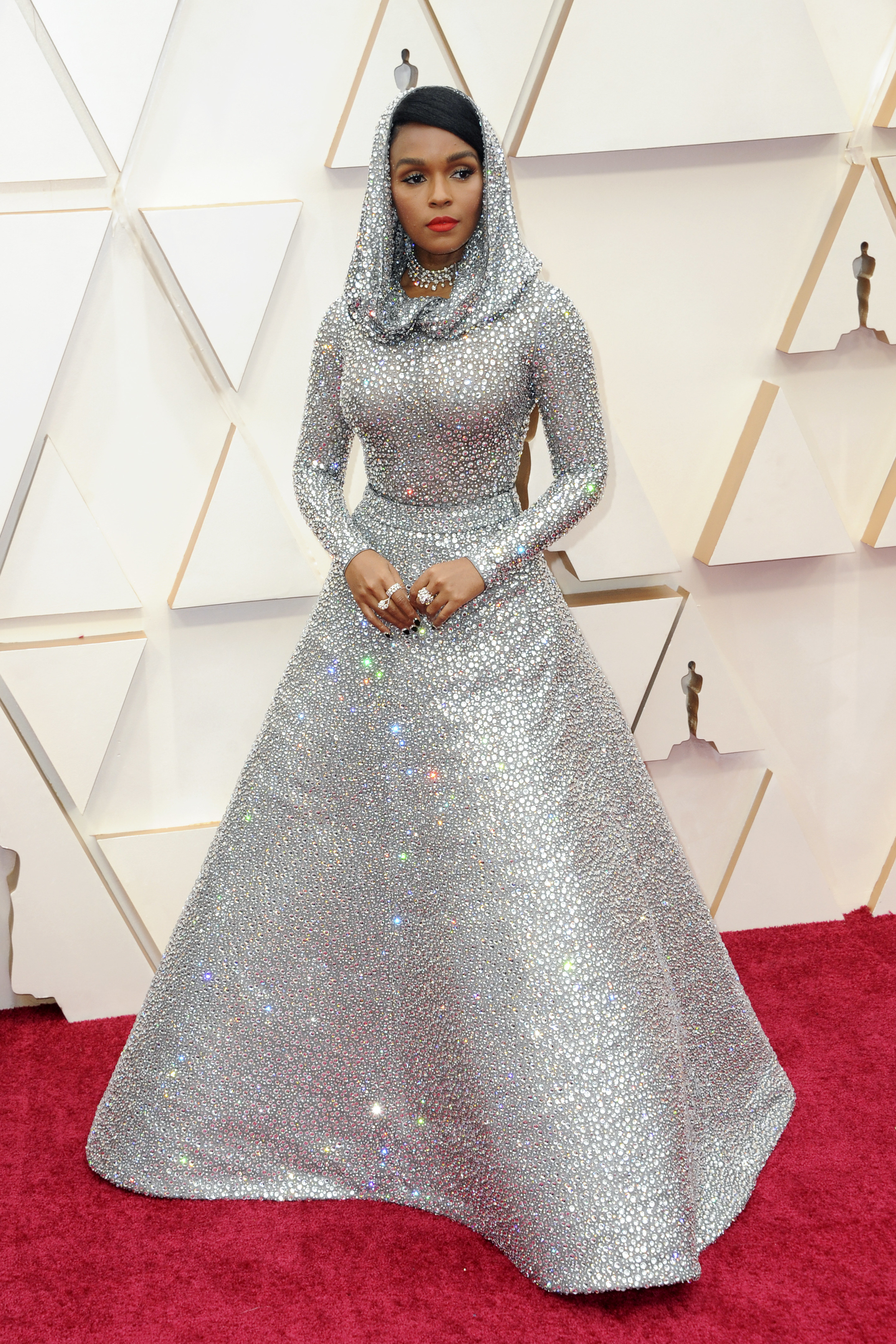 Janelle wearing a sparkling silver gown with a hood