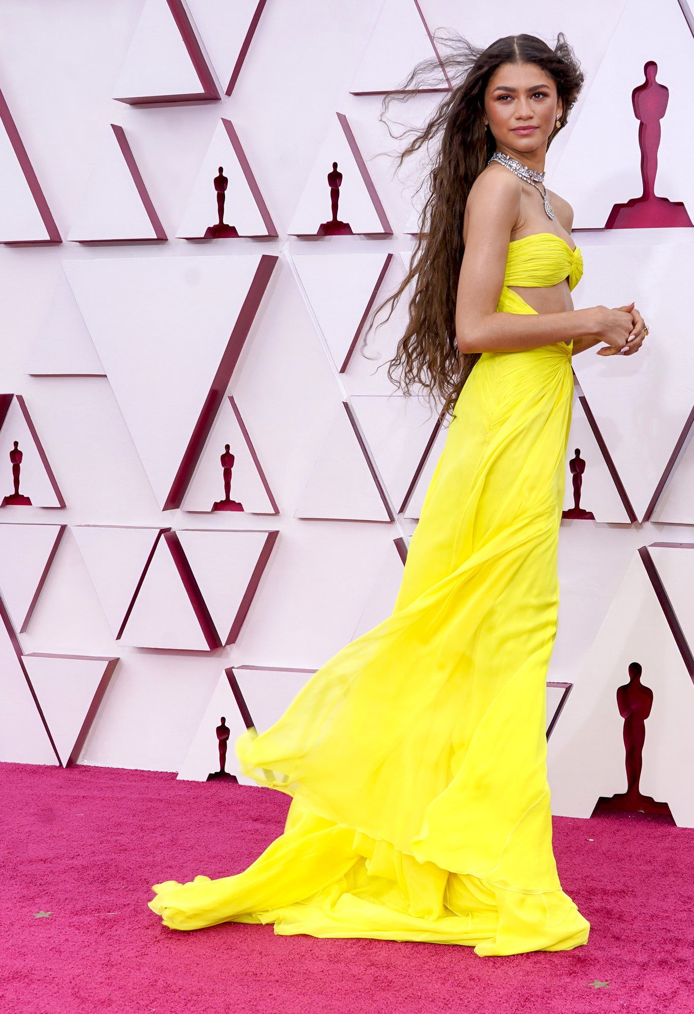 Zendaya穿着一件亮黄色长袍,头发流动